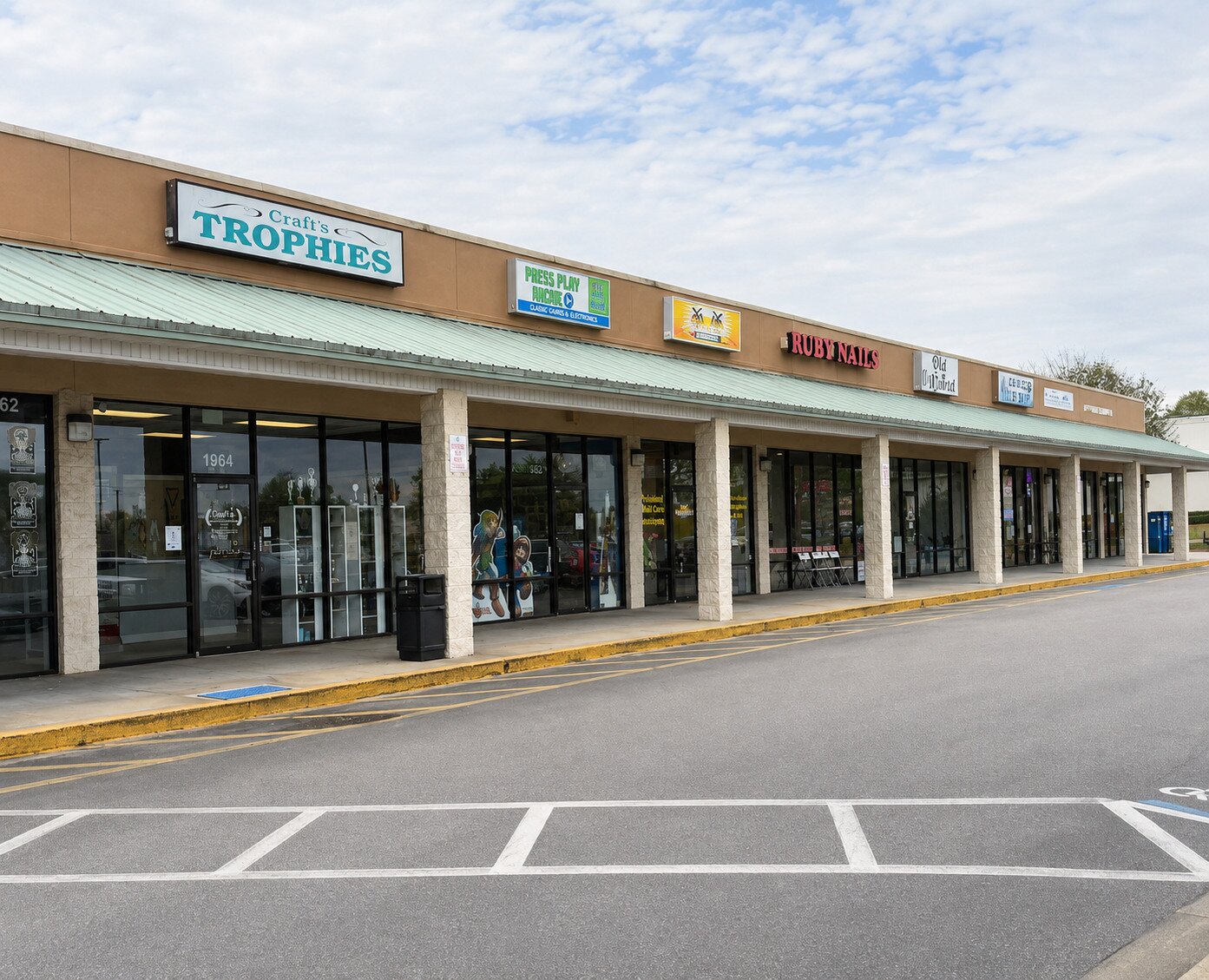 Clean storefront walk, curb line, and parking approach at a neighborhood shopping center